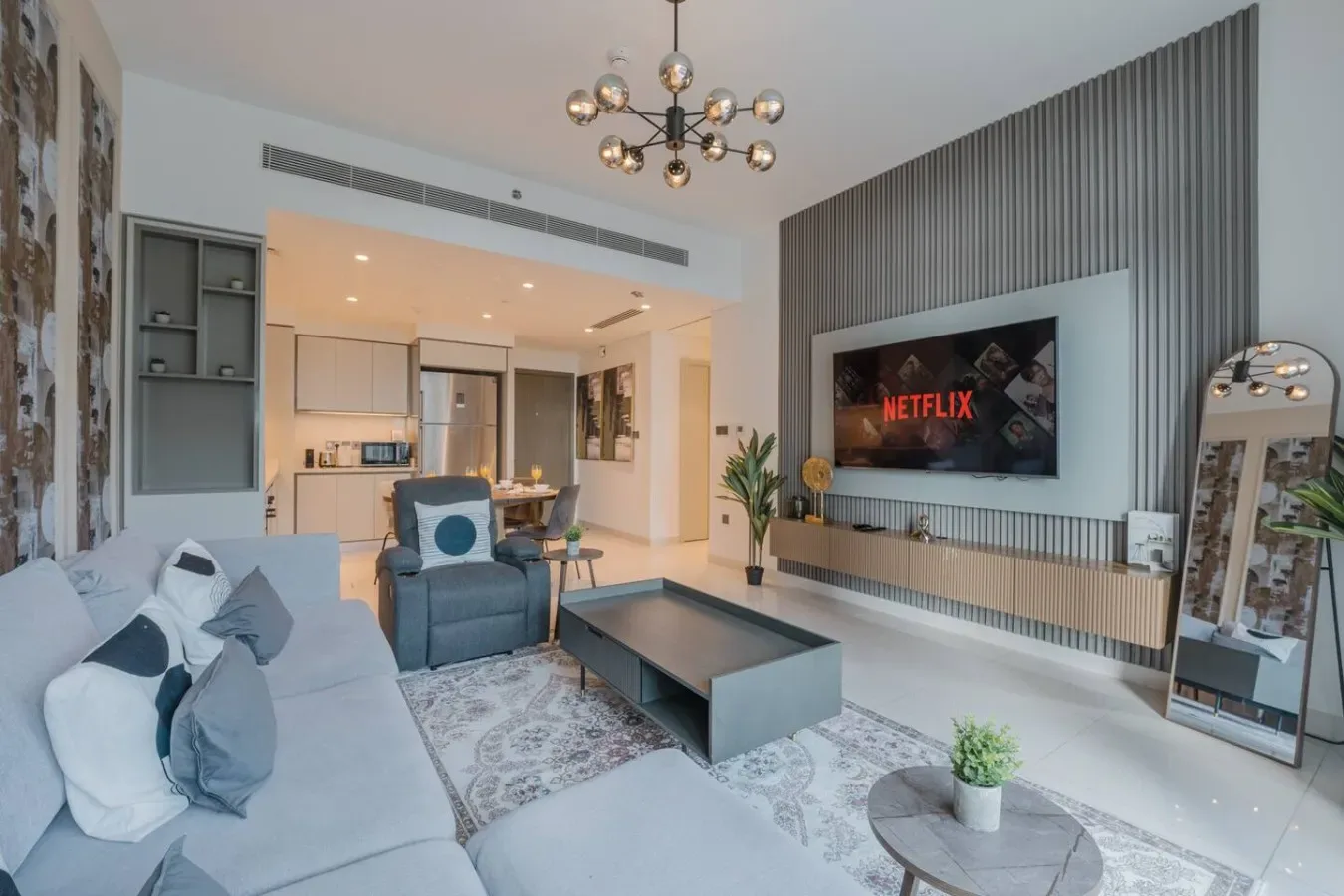 Una sala de estar moderna con asientos, una mesa de centro y un televisor en la pared.