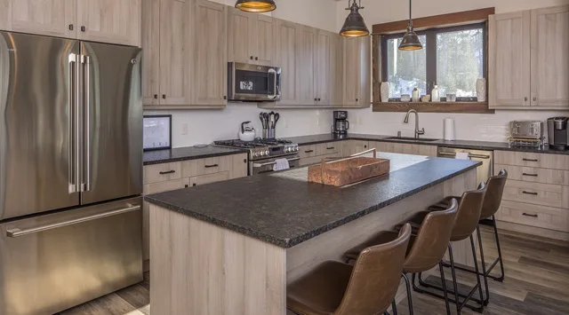 Una cocina moderna con gabinetes claros y una gran isla central.