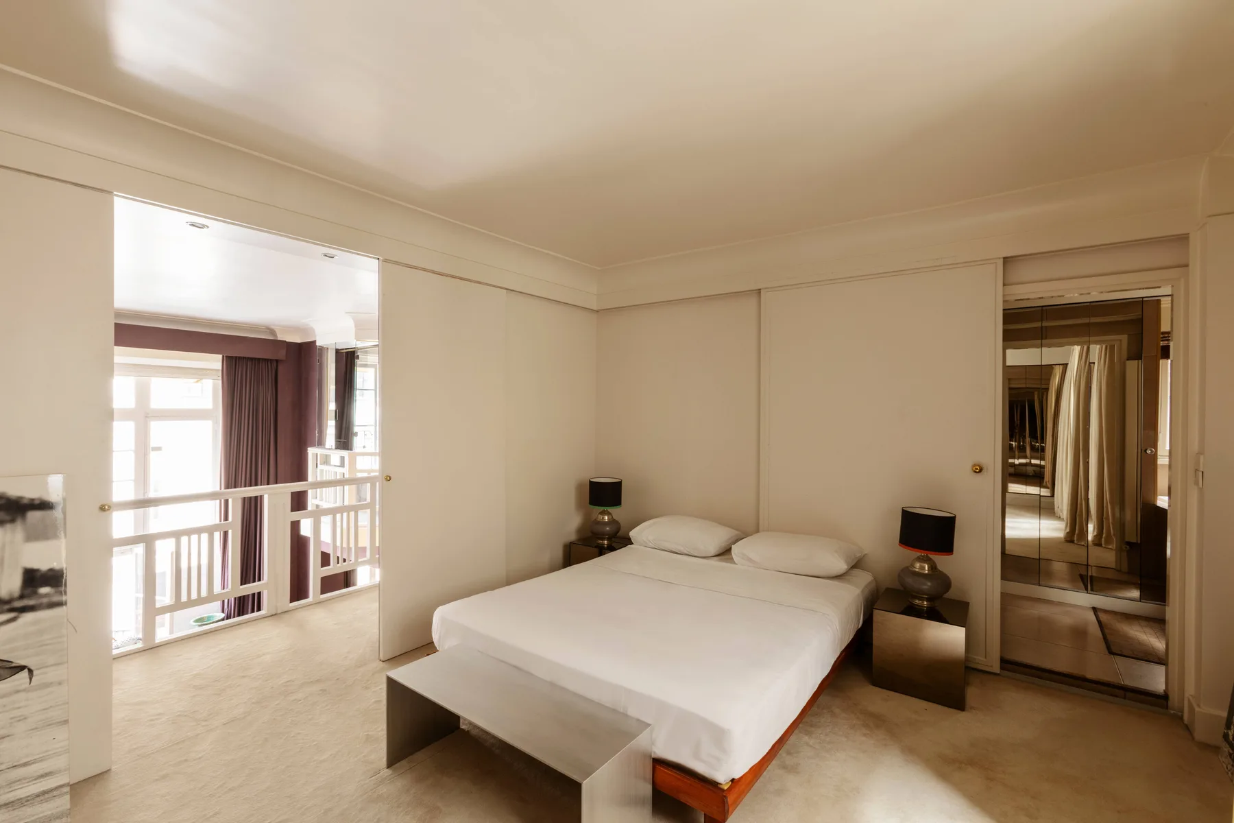 Un dormitorio con una cama bien tendida y una mesa de noche.