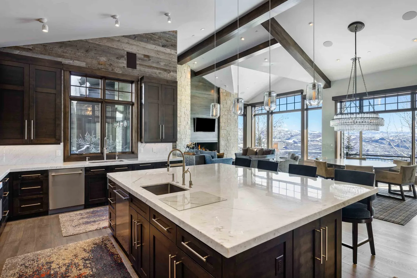 A spacious kitchen with a large island and tall windows.