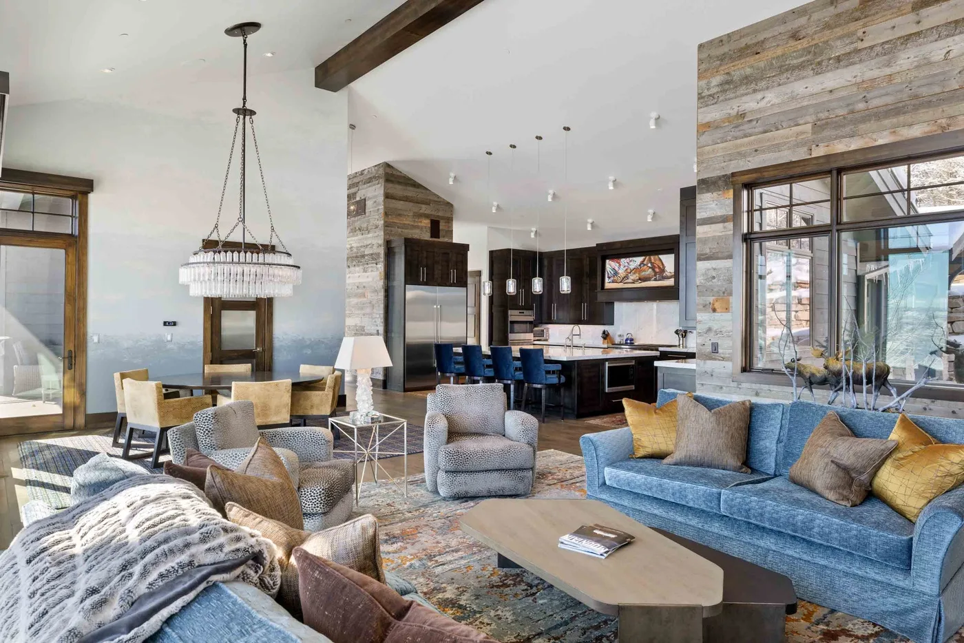 An open living room and kitchen with seating arranged around a low coffee table.