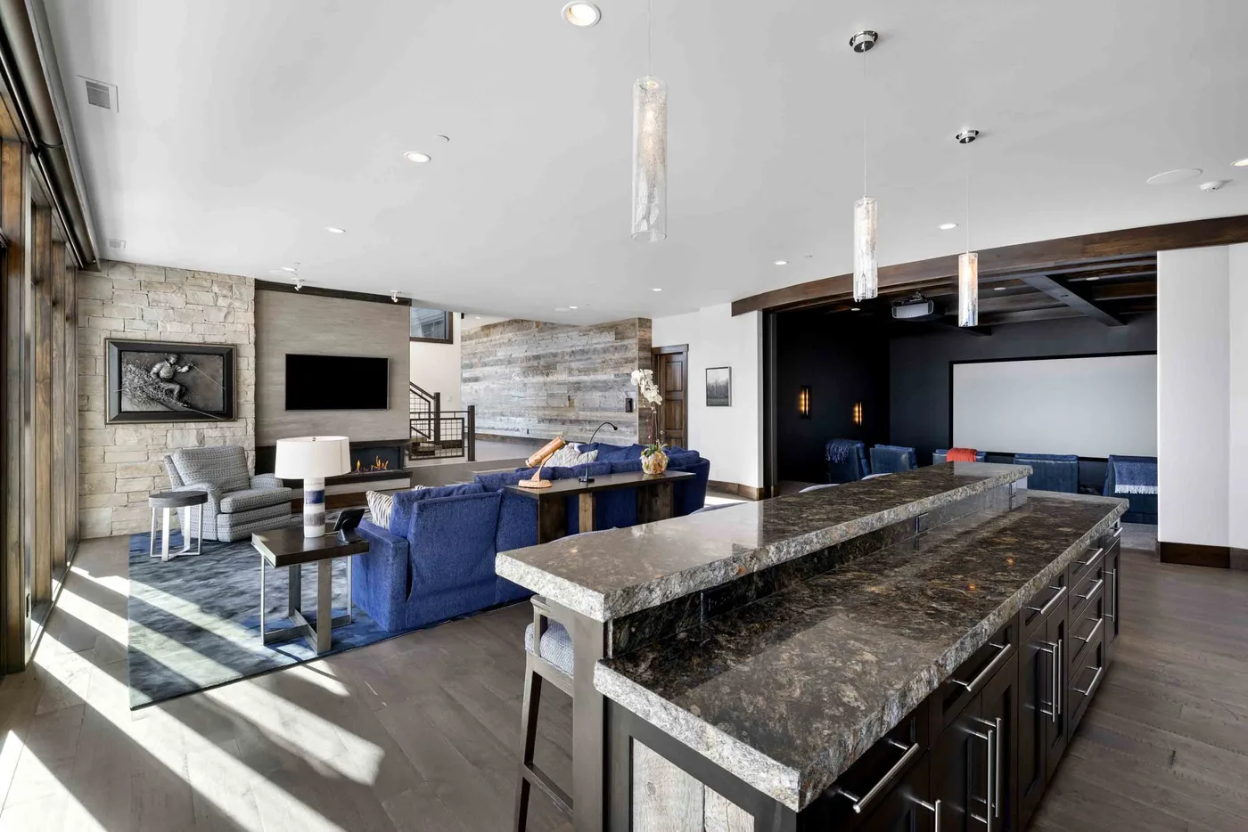 An open-plan kitchen and living area with a large island and blue seating.