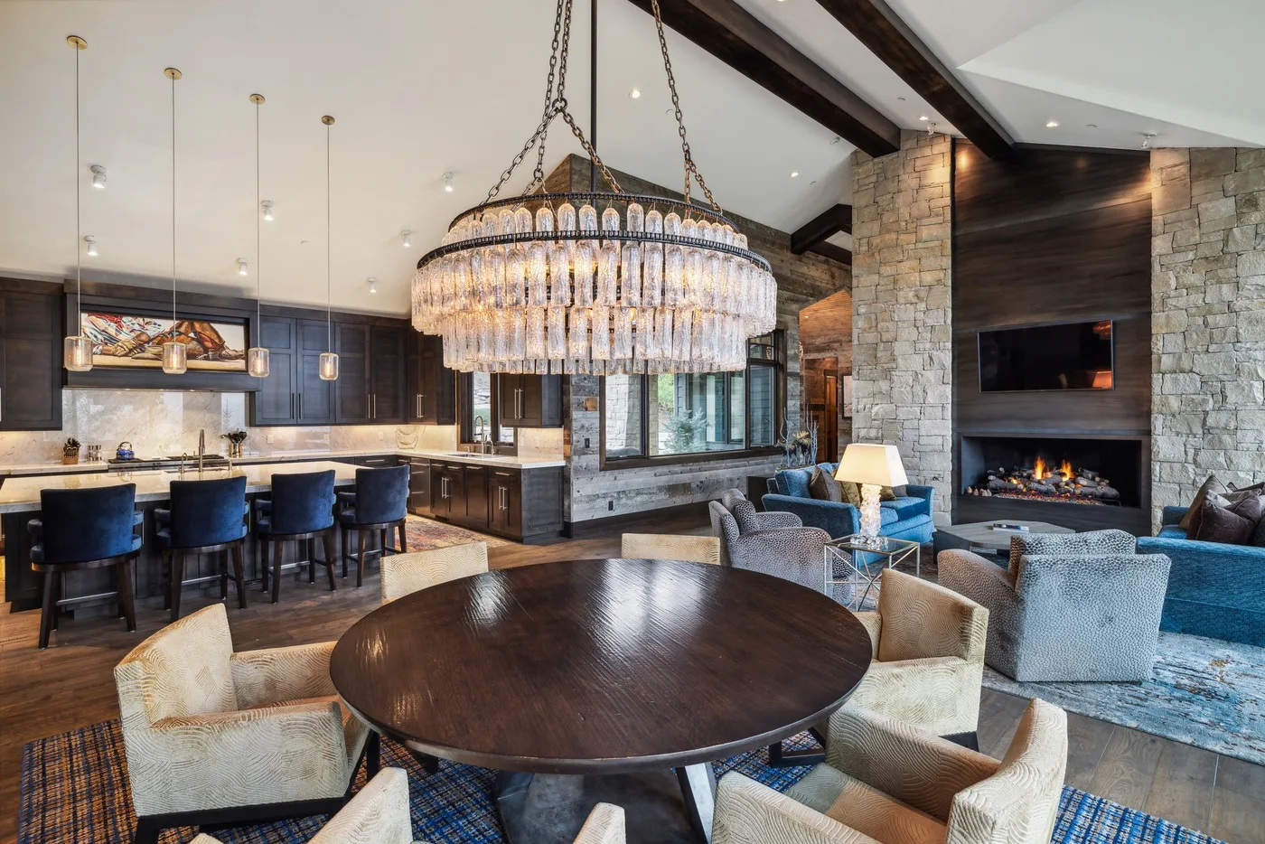 A spacious living and dining area with a kitchen, seating, and a fireplace.