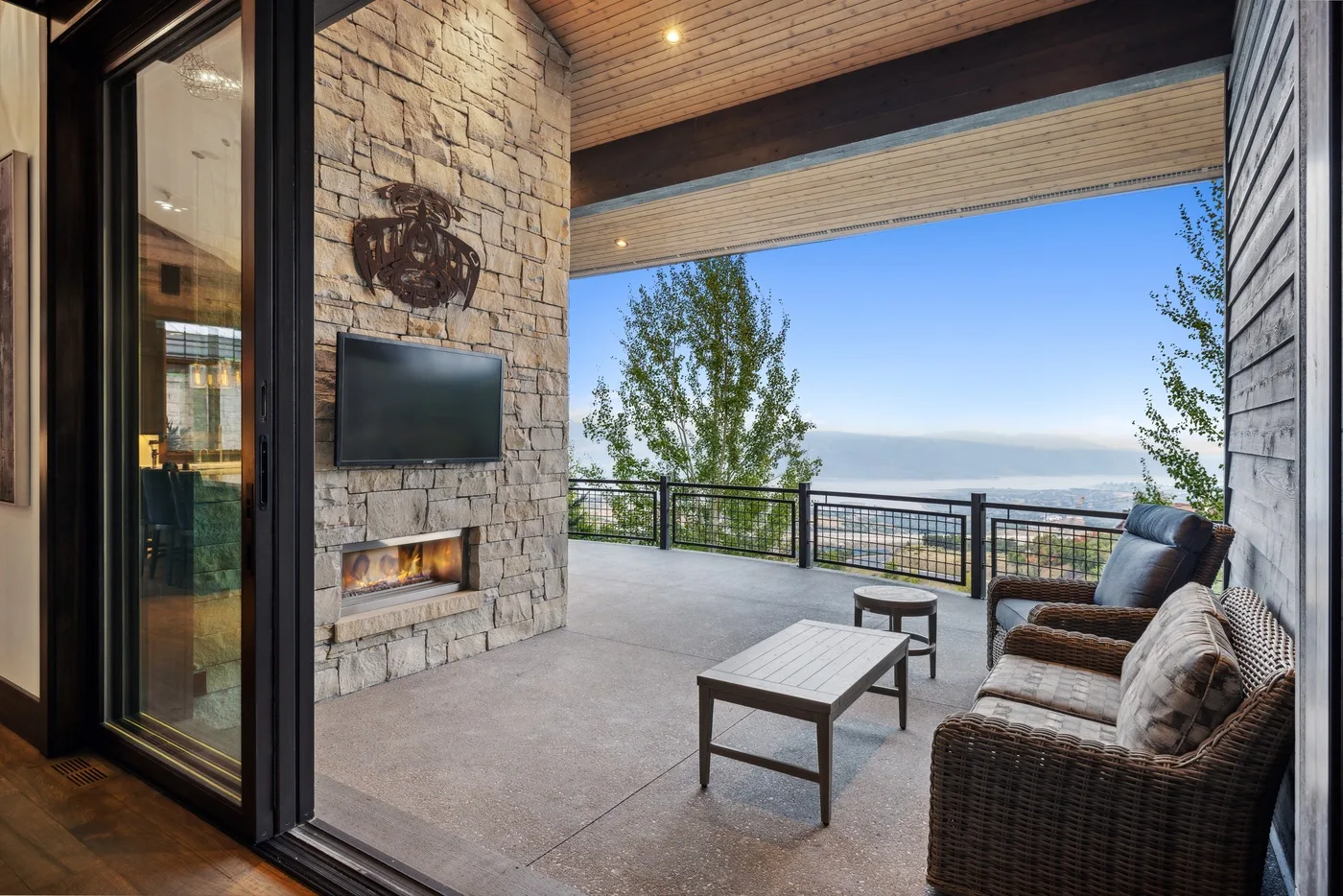 A covered outdoor lounge with seating and a view of the landscape.