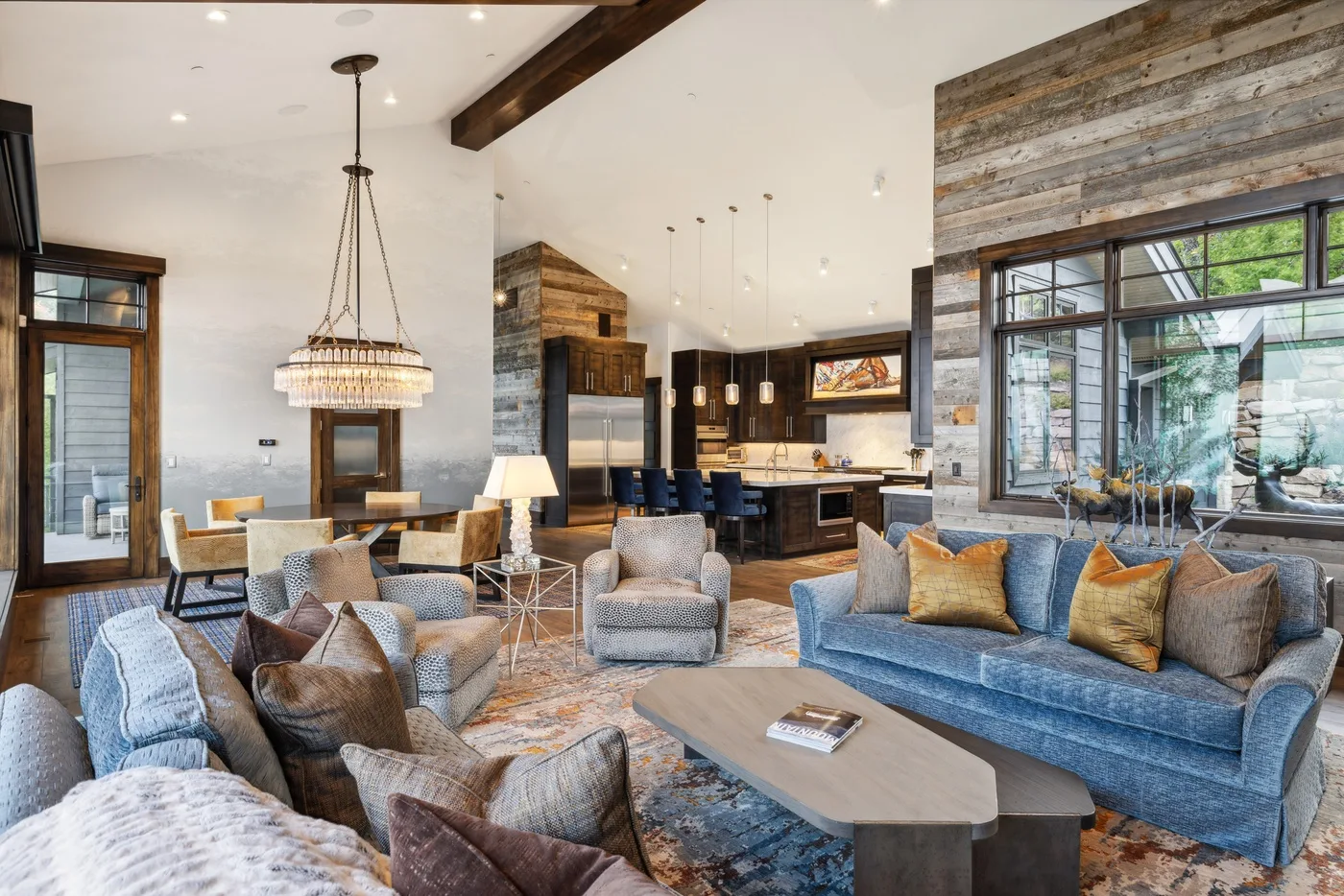 A spacious living room with seating arranged around a coffee table beside the kitchen.