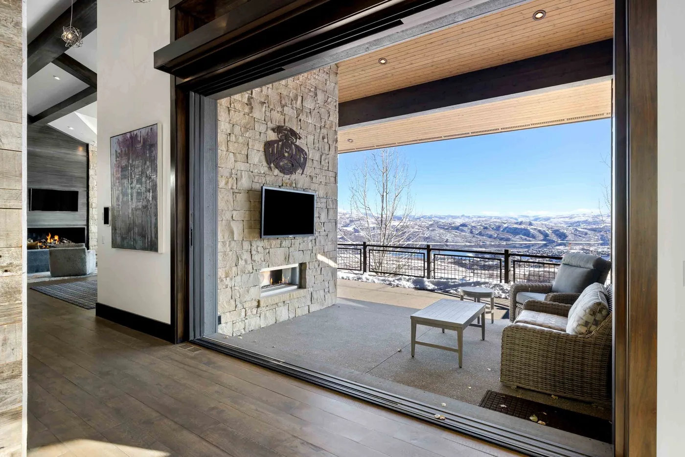 A spacious living area opens onto a furnished terrace with mountain views.
