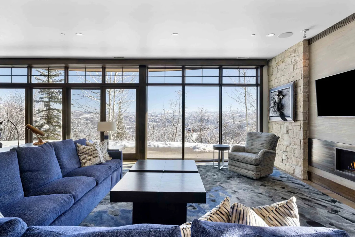 A living room with large windows overlooking a snowy landscape.