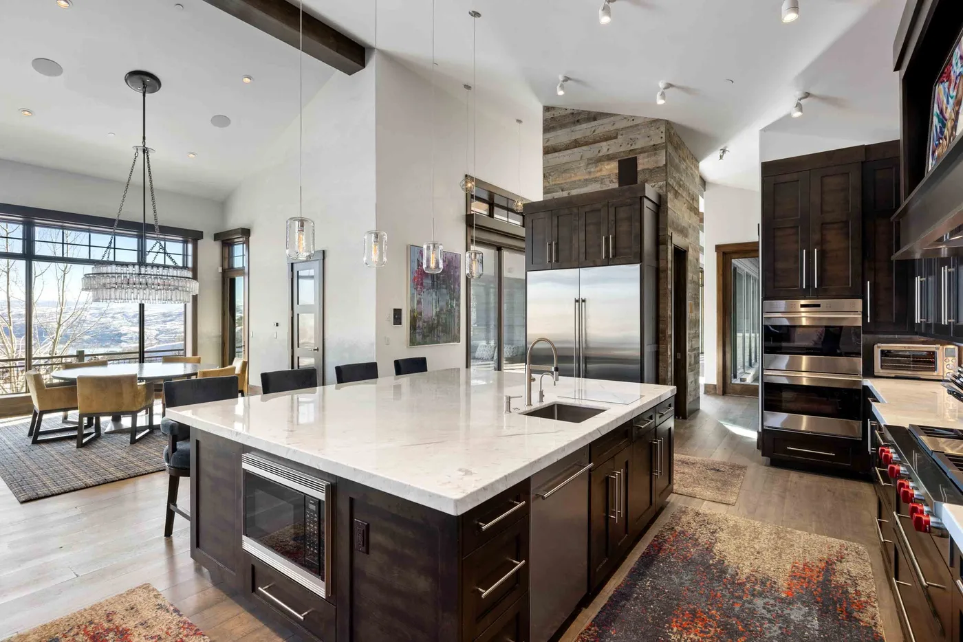 An open kitchen and dining area with a large island and windows.
