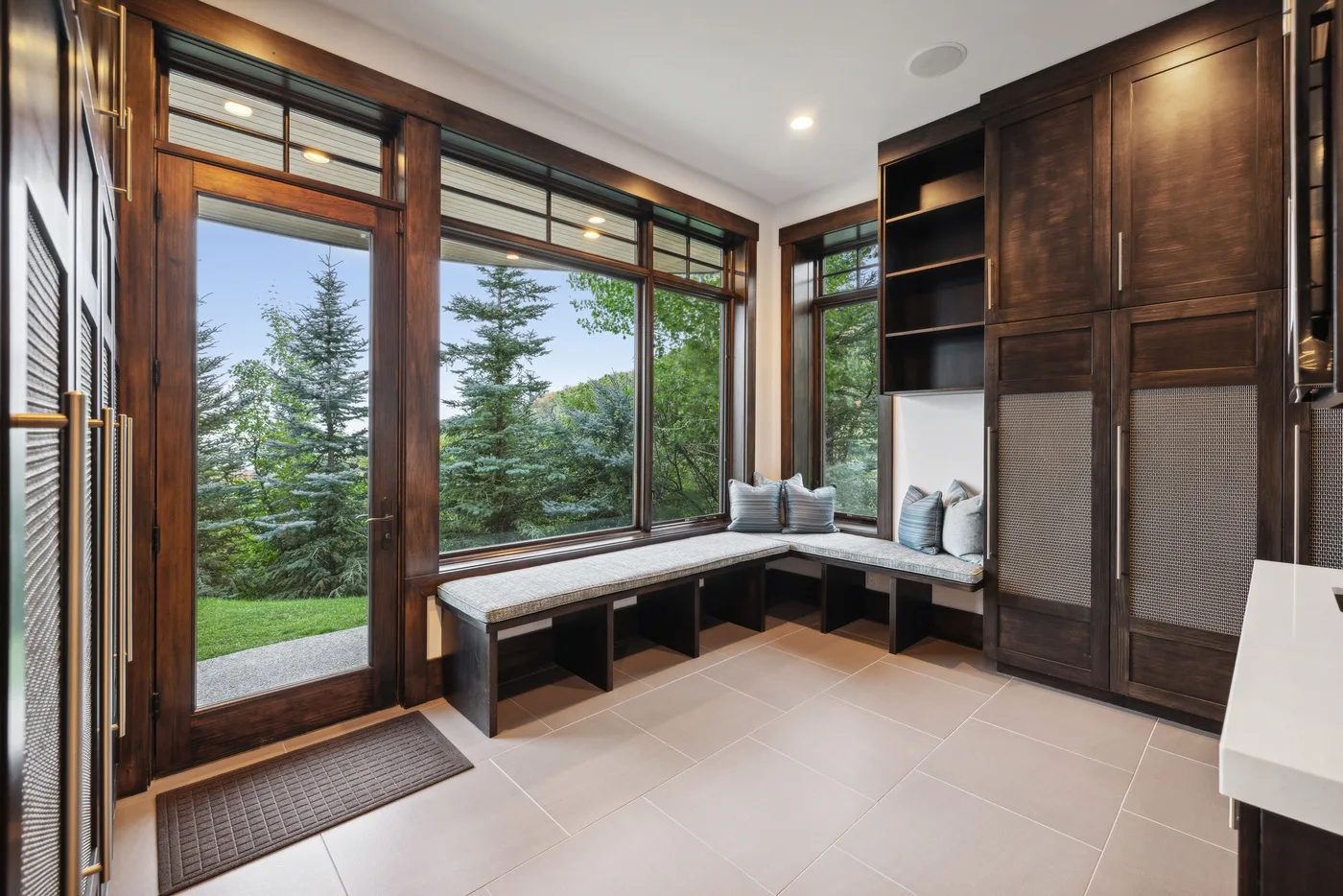A windowed sitting area with a built-in bench and views of trees.