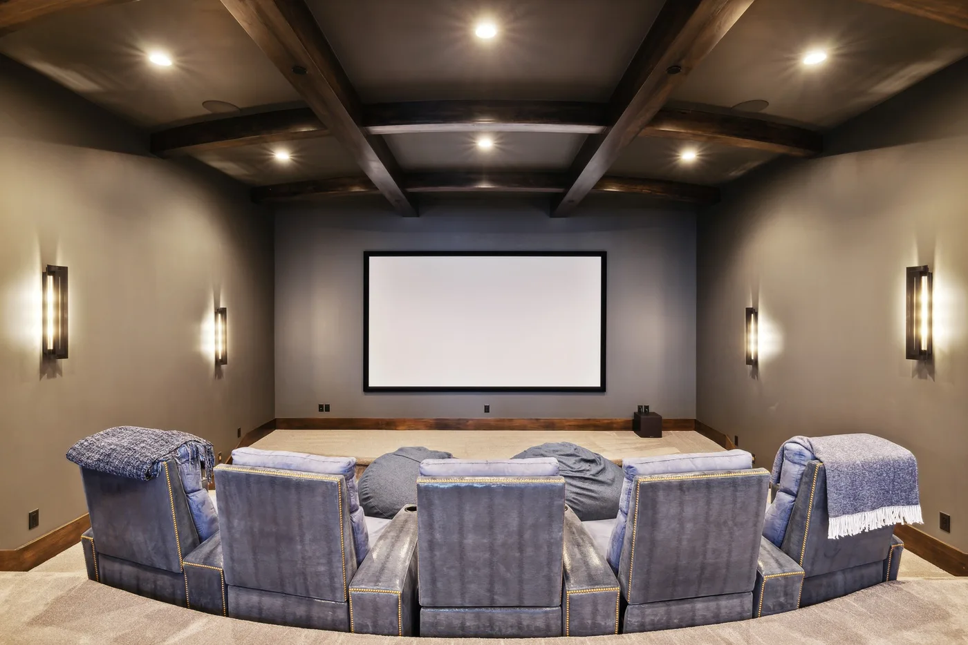 A home theater with rows of seating facing a large projection screen.