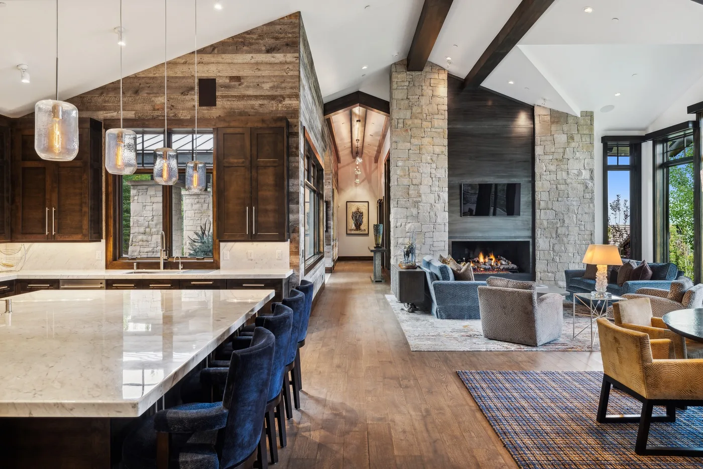 An open-plan living room and kitchen with a fireplace and dining island.