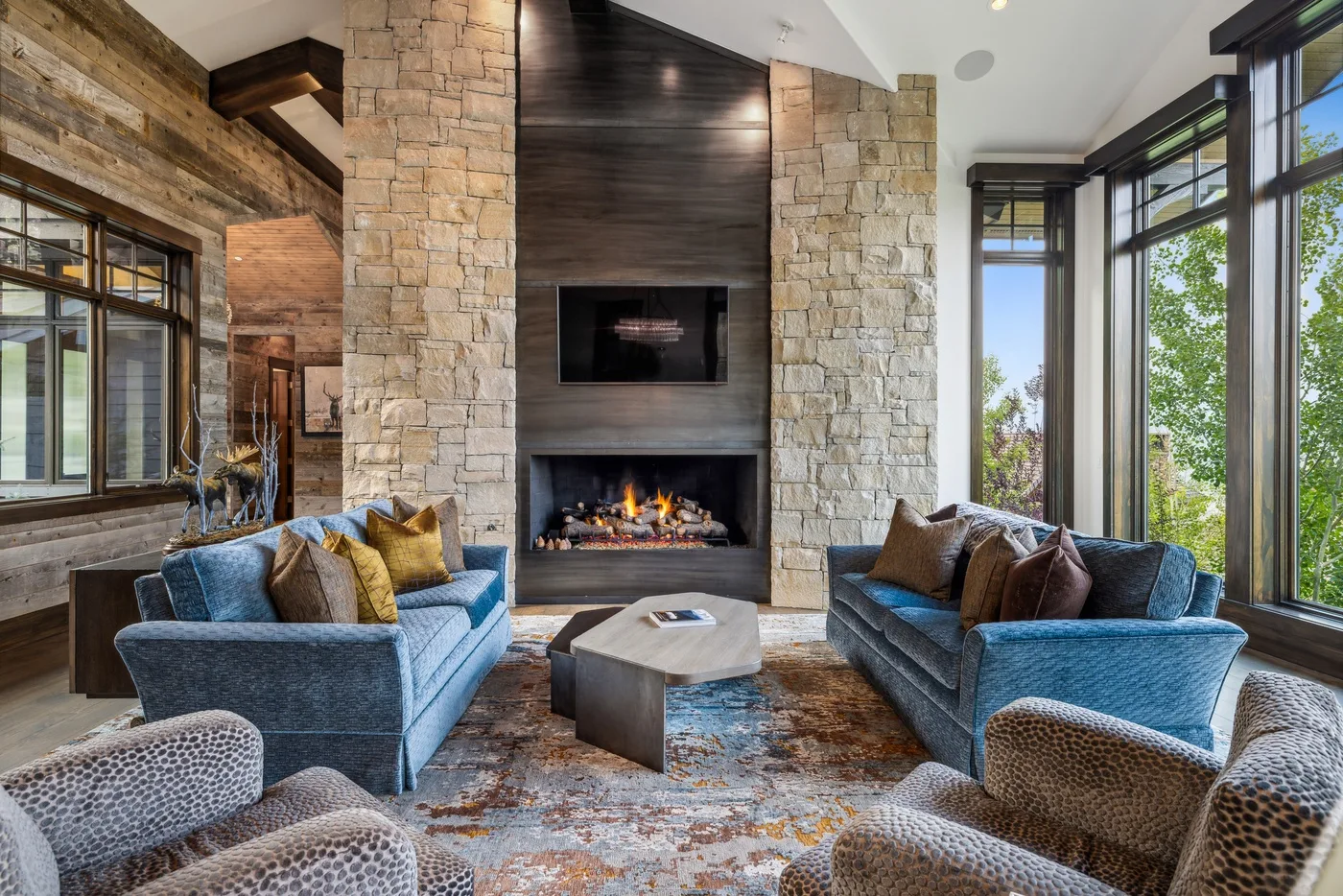A bright living room has seating arranged around a fireplace and coffee table.