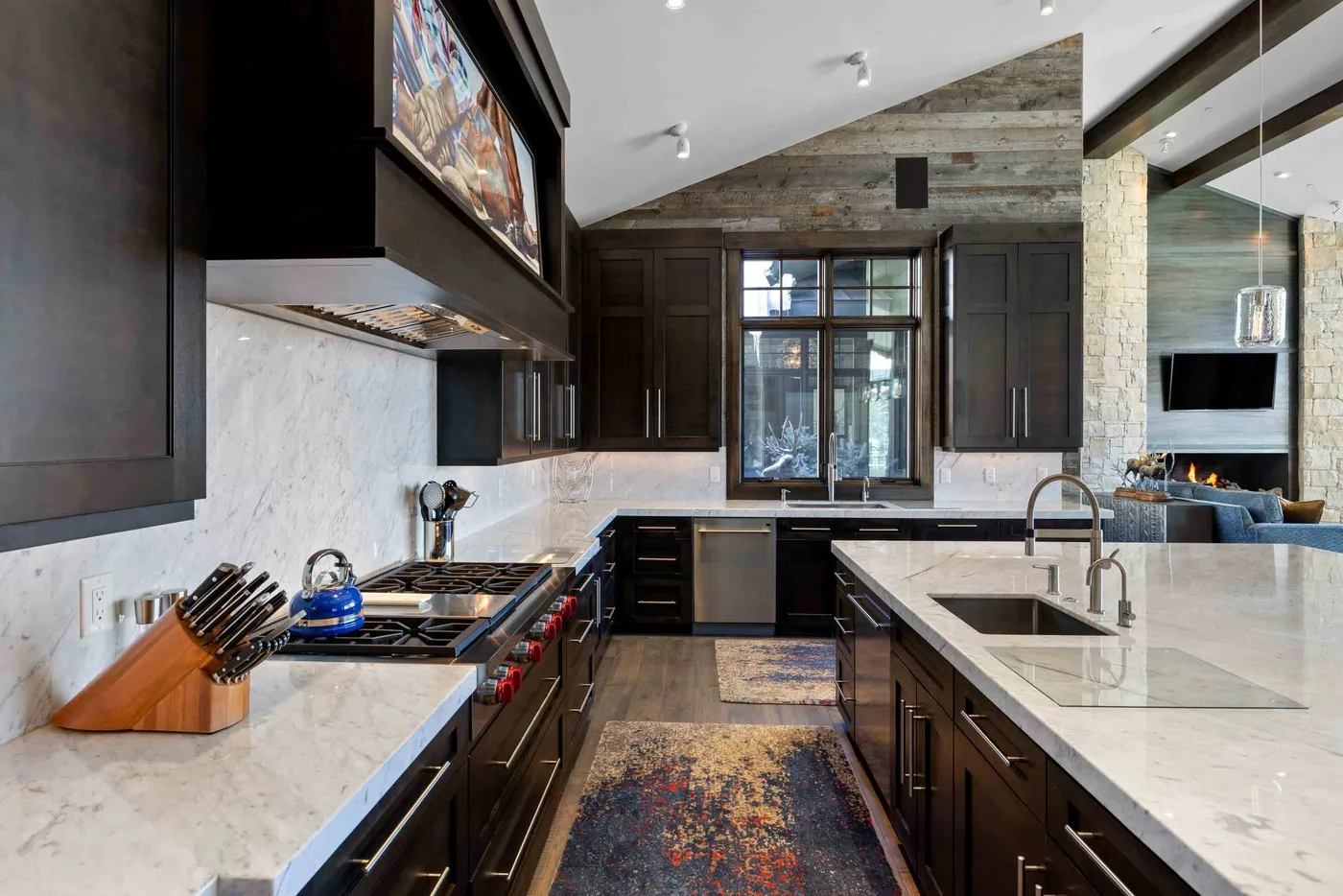 A spacious kitchen with dark cabinetry, pale countertops, and a central island.