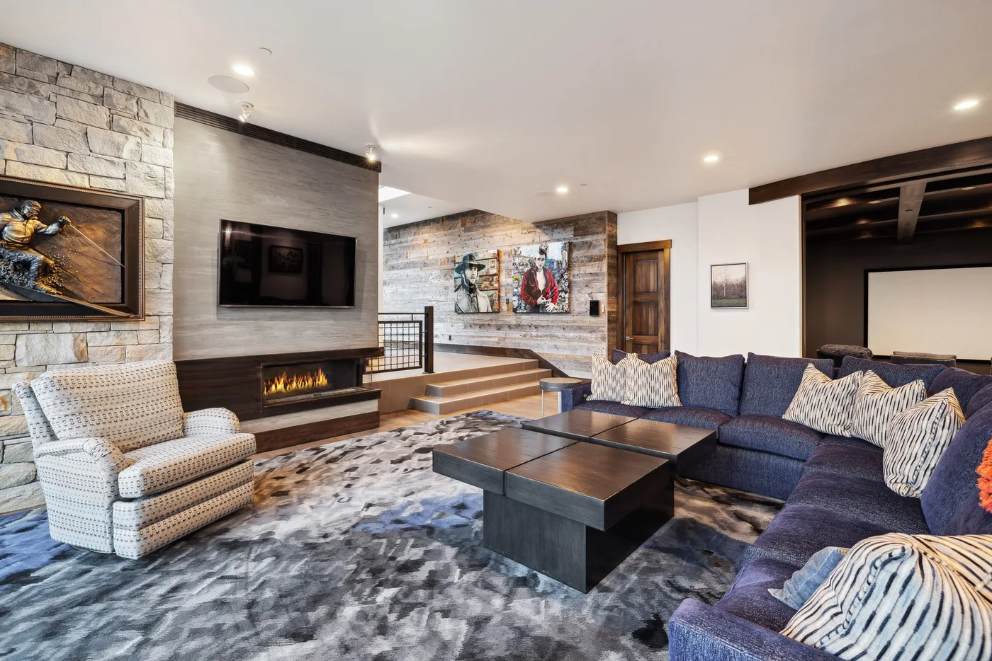 A spacious living room with seating arranged around a coffee table and fireplace.