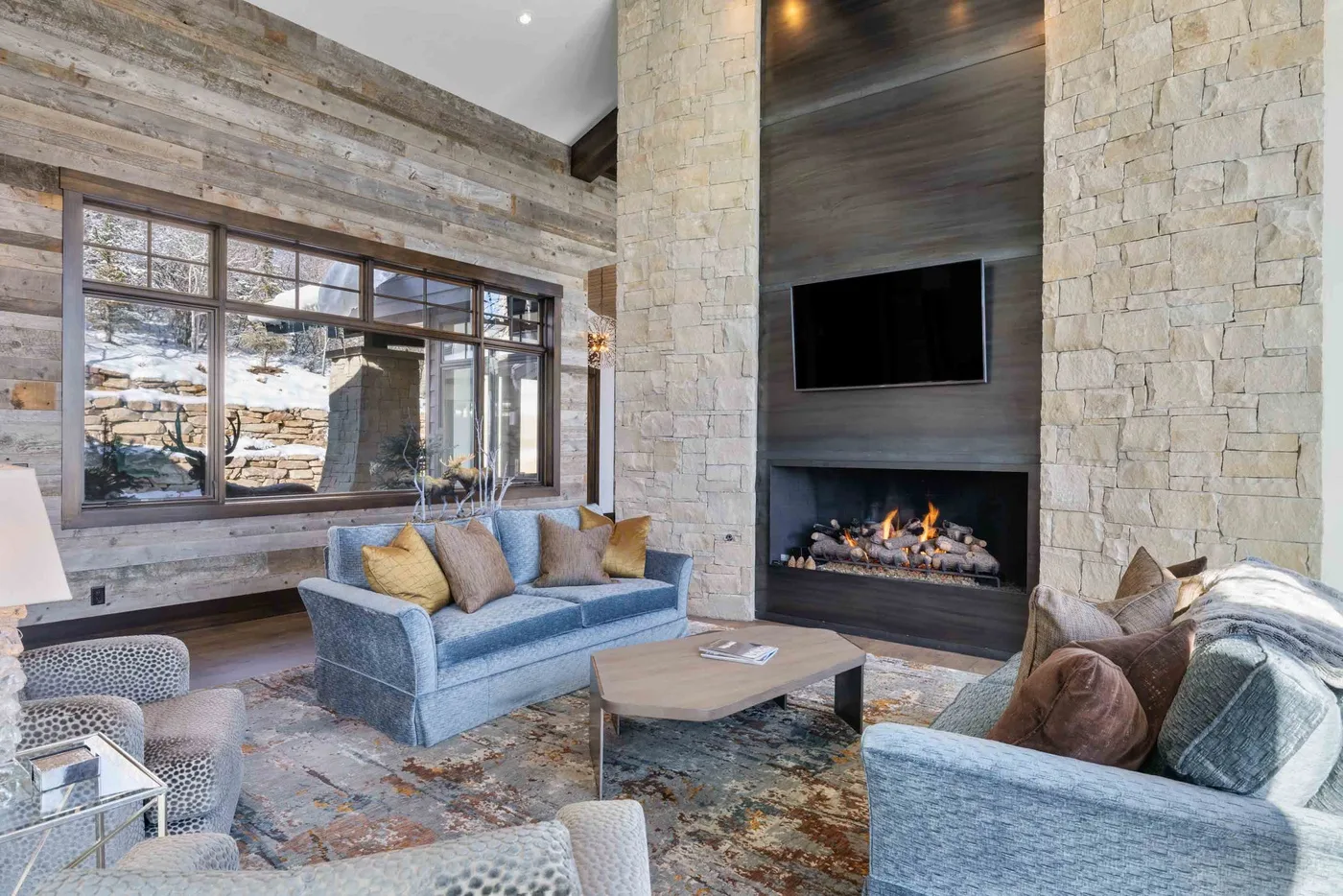 A living room with seating arranged around a fireplace and television.