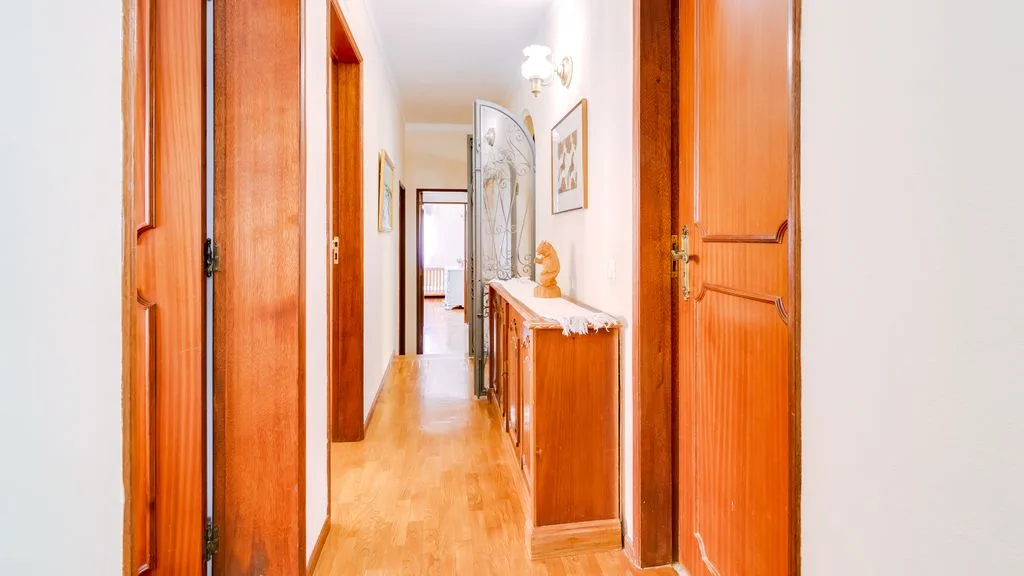 A bright hallway with wooden doors and a narrow console table.