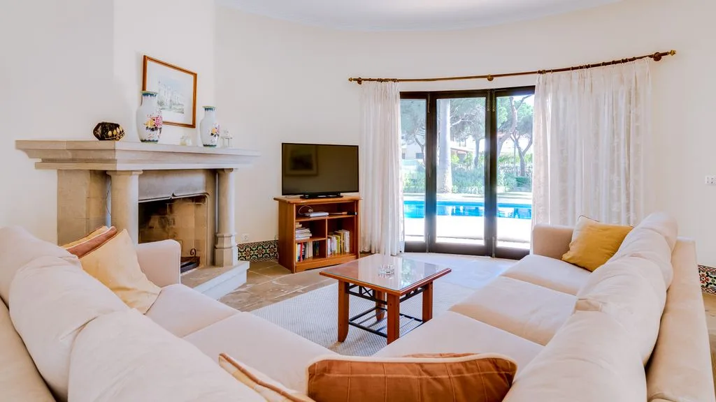 A bright living room with cream seating and a coffee table.