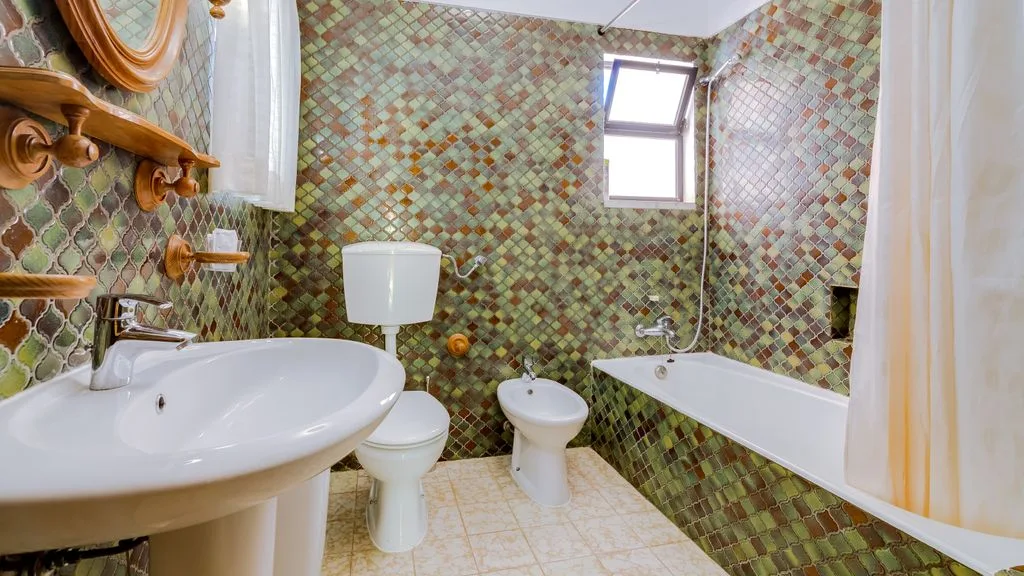 A tiled bathroom with a bathtub, sink, and toilet.