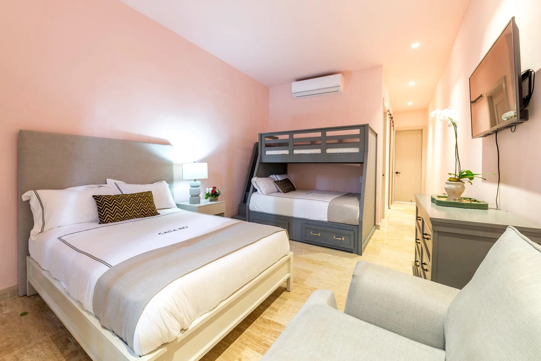 Un dormitorio con una cama doble, literas y un televisor.