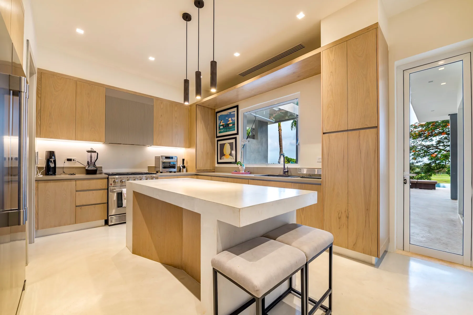 Una cocina moderna y luminosa con una isla grande y taburetes.