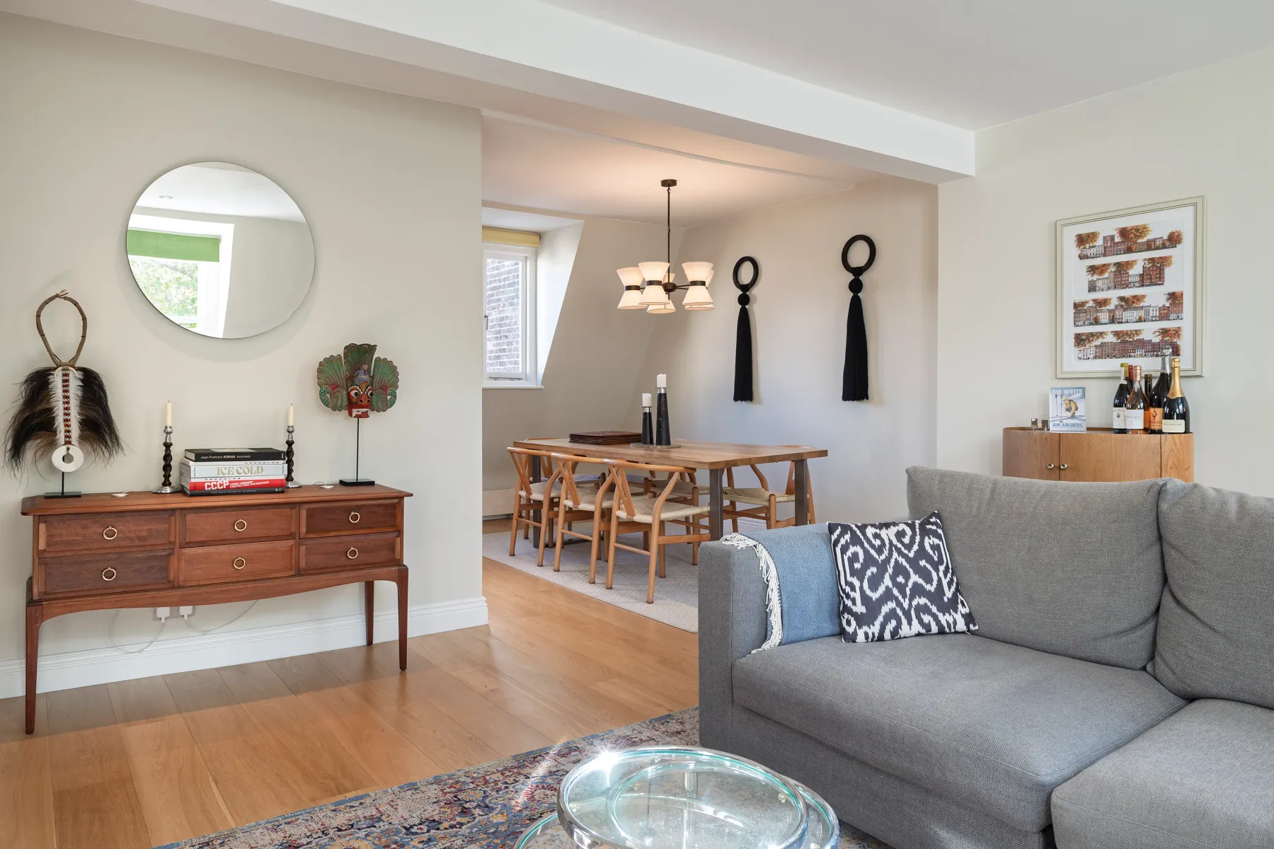 A living and dining area with a gray sofa and a wooden dining table.