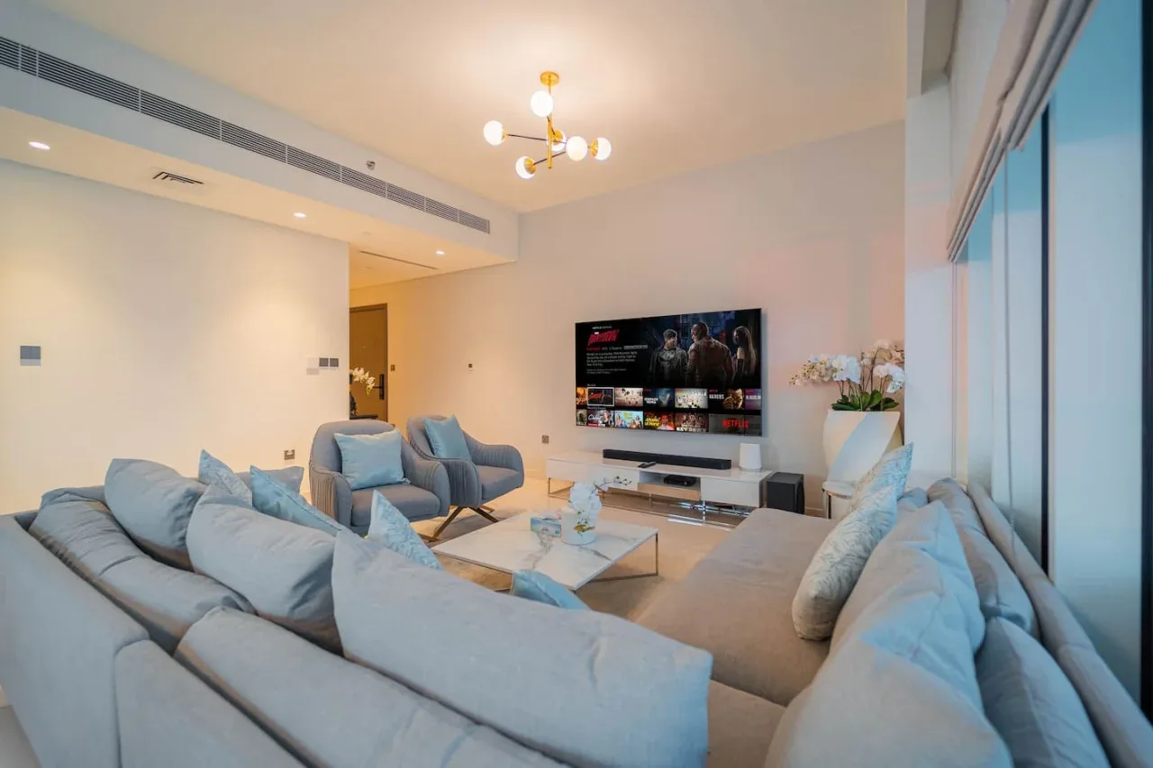 A bright living room with seating arranged around a television.