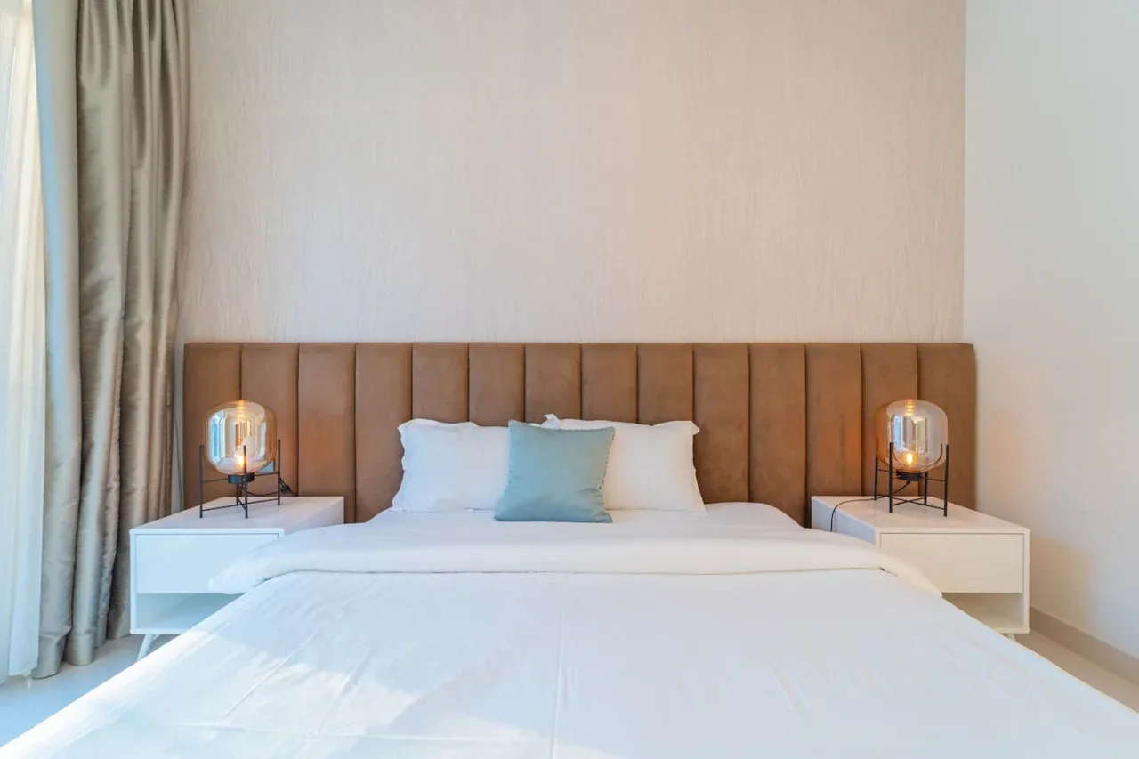 A bedroom with a neatly made bed and matching bedside tables.