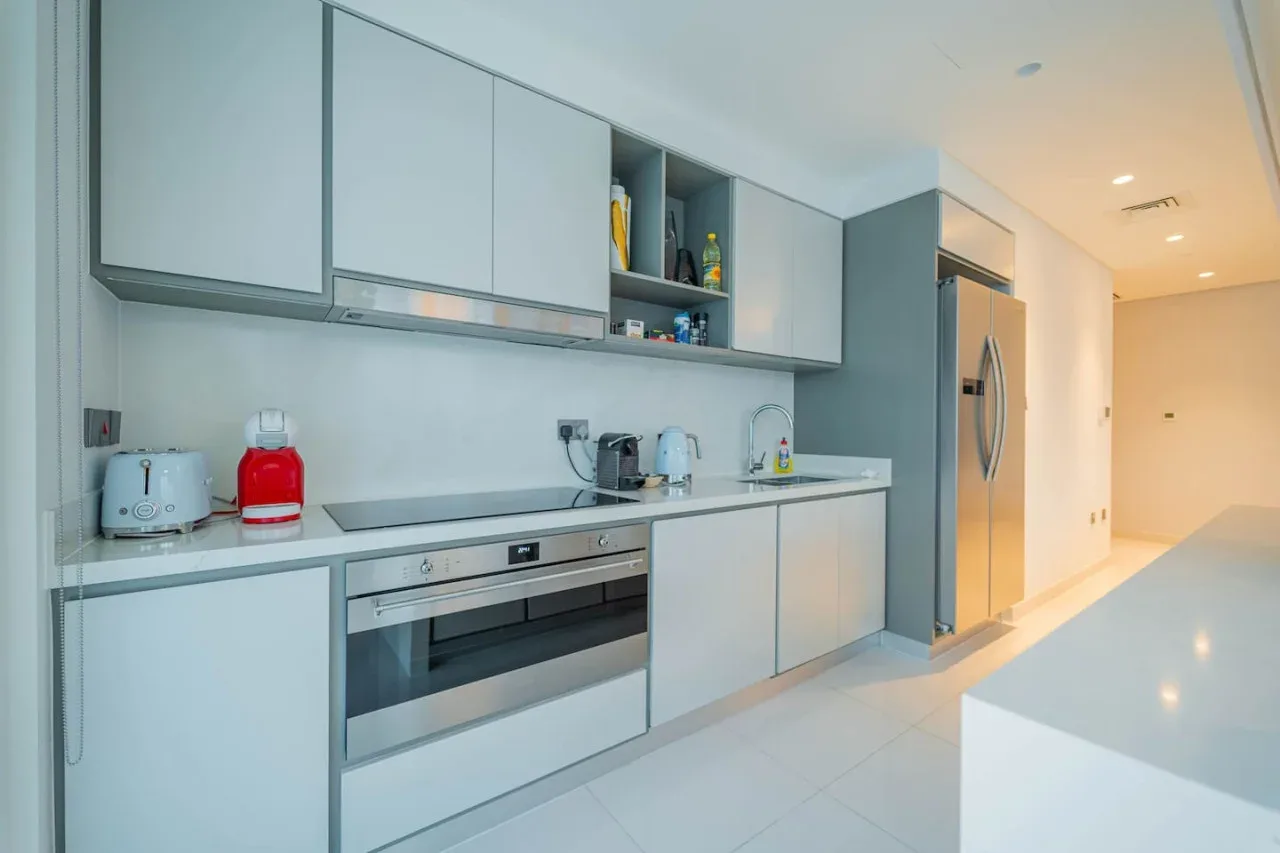 A modern kitchen with built-in appliances and a long countertop.