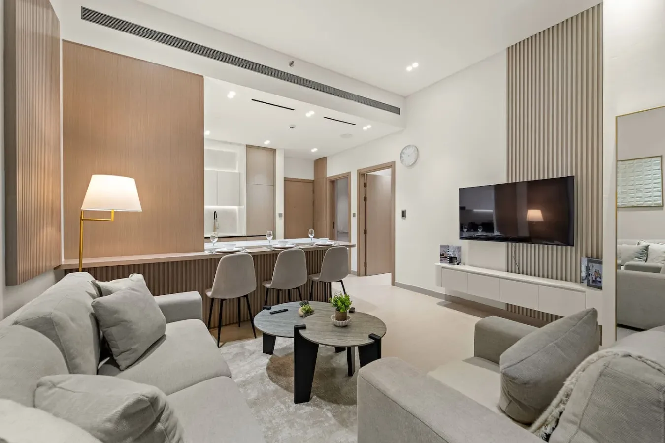 Una sala de estar moderna con asientos, una mesa de centro y un televisor.
