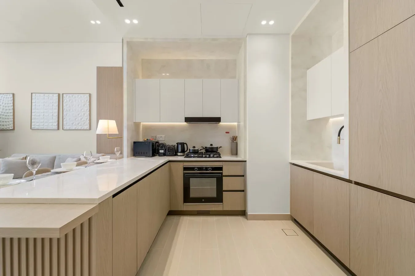 Una cocina moderna con armarios de madera clara y un horno integrado.