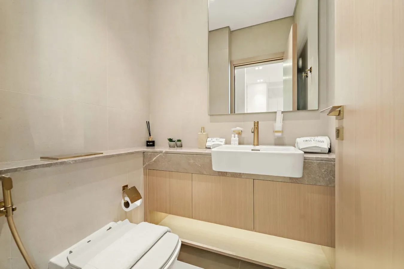 Un baño con lavabo, espejo e inodoro.