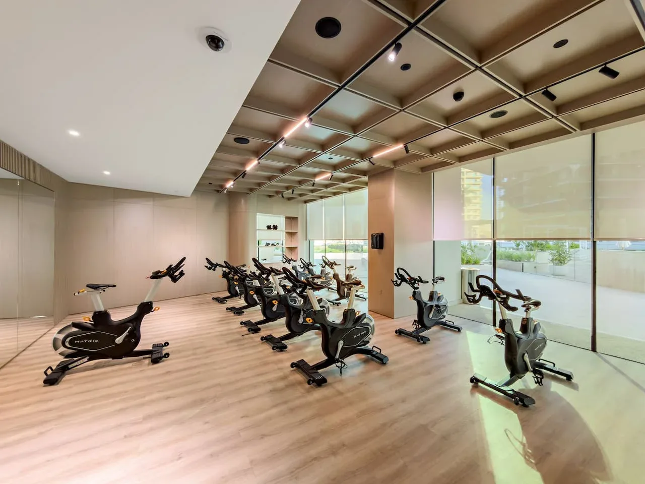 Un estudio de ejercicio interior con bicicletas estáticas y grandes ventanales.