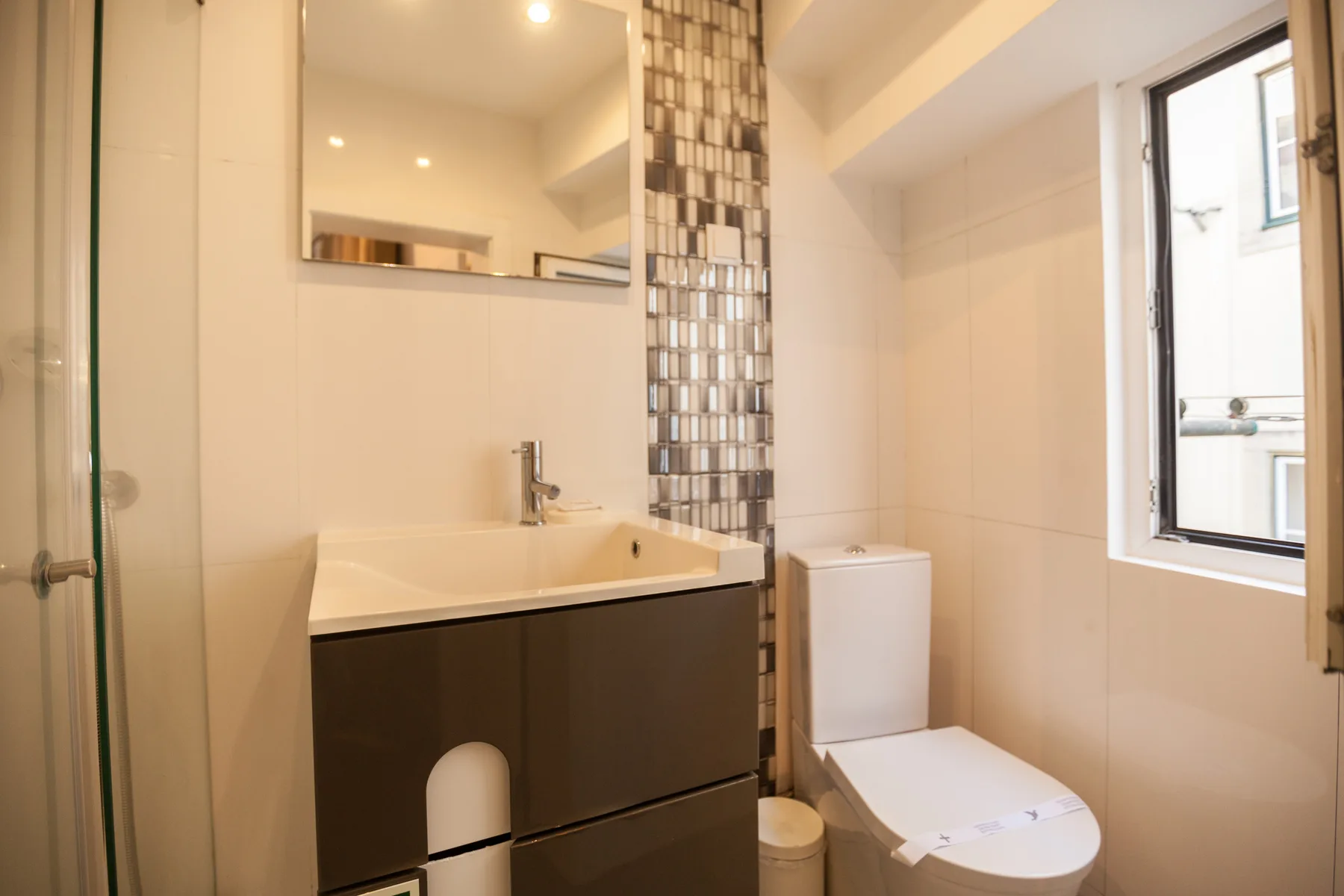 Un baño con lavabo, inodoro y ventana.