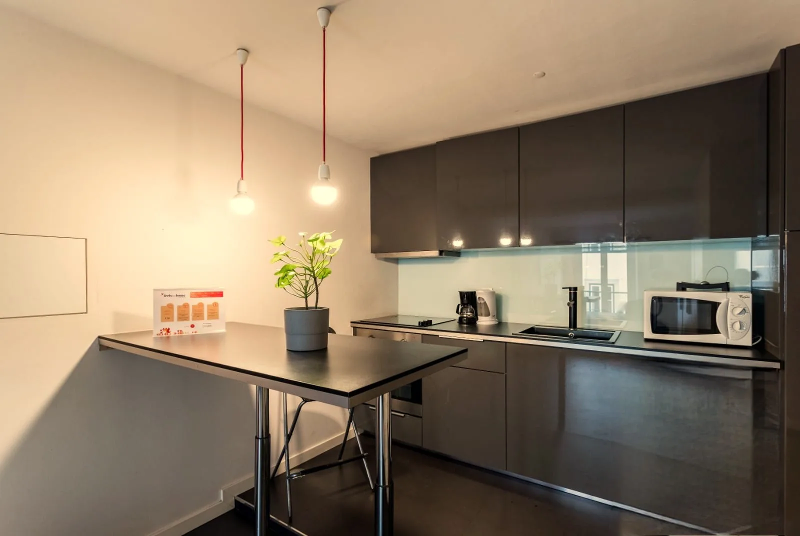 Una cocina compacta con armarios oscuros y una pequeña mesa de comedor.