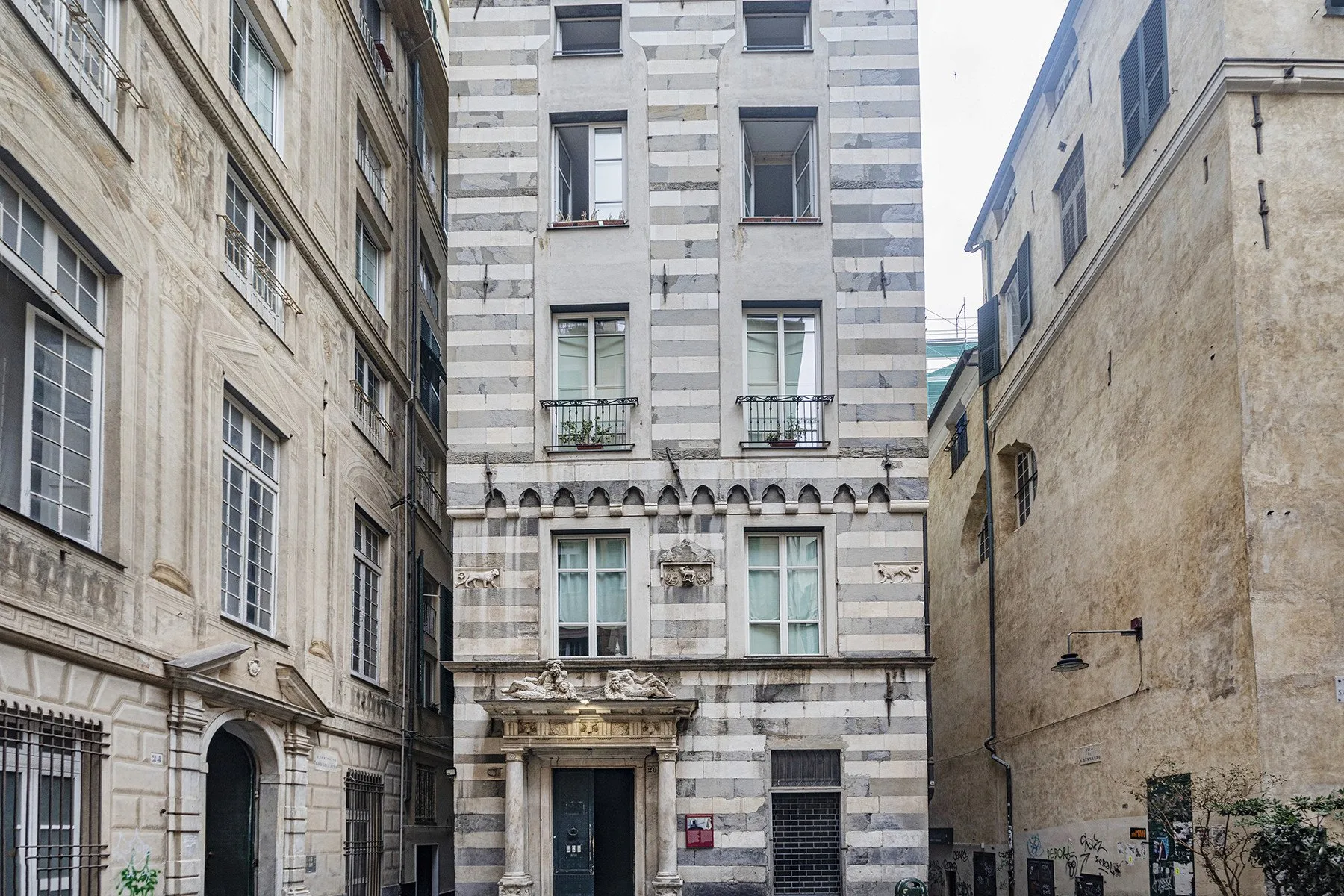 Un patio urbano estrecho rodeado de edificios altos de piedra.