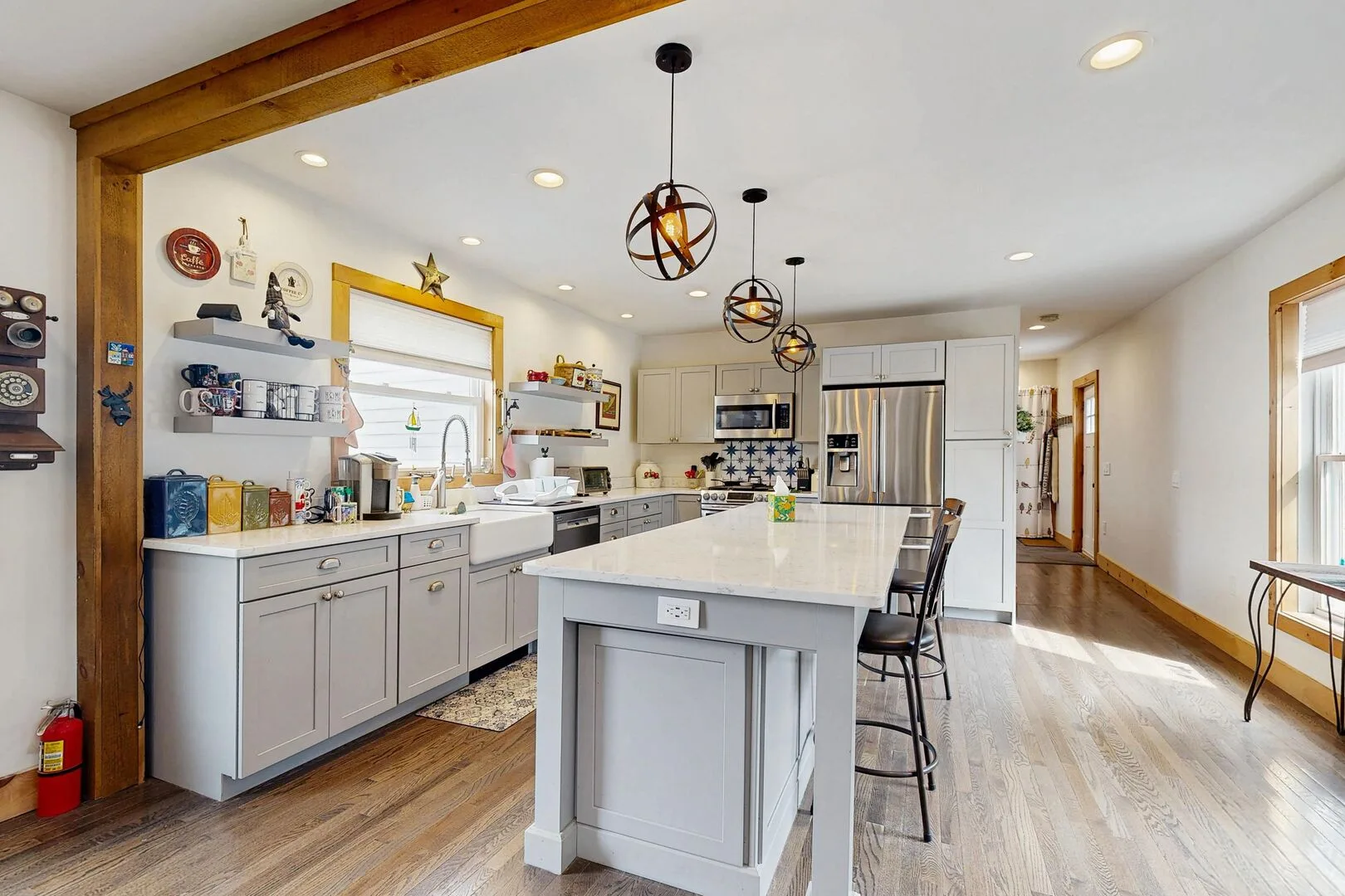 A bright kitchen with a large island, light cabinetry, and pendant lights.