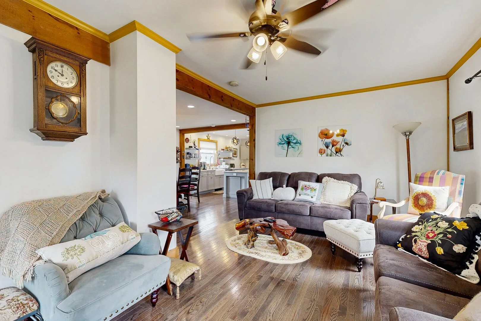 A living room with several seating areas, a coffee table, and wall art.