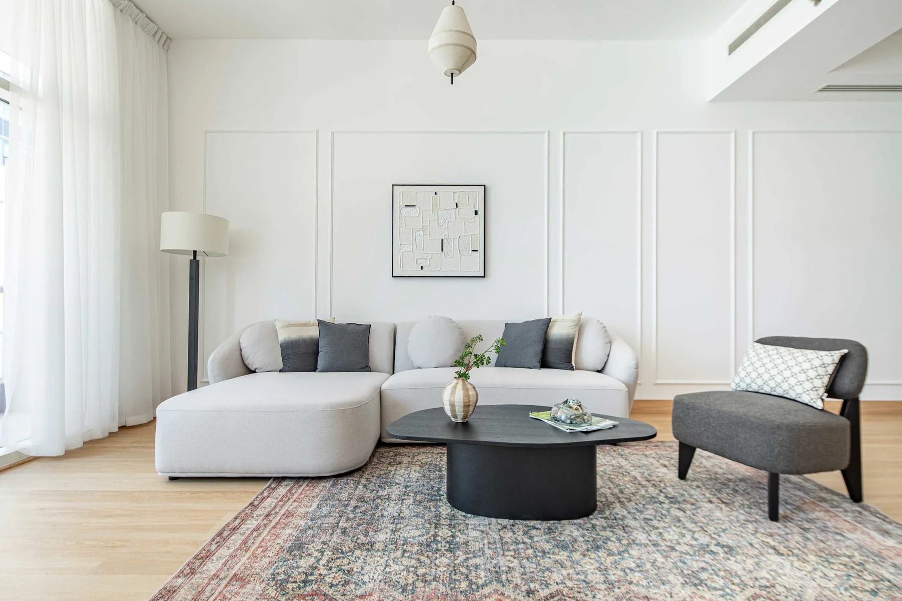 Una sala de estar luminosa con sofá seccional, mesa de centro y sillón.