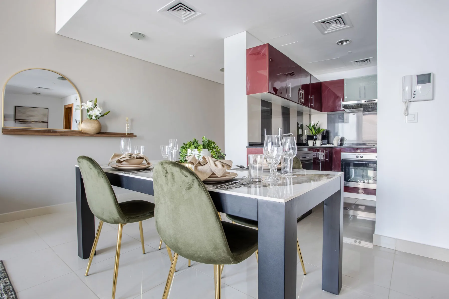 Comedor con una mesa puesta y una cocina abierta al fondo.