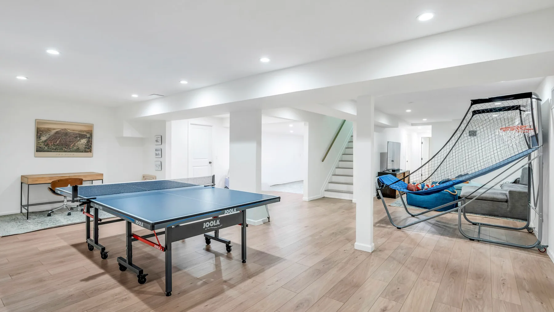 Una sala de recreación con una mesa de ping-pong y una zona de asientos con red.
