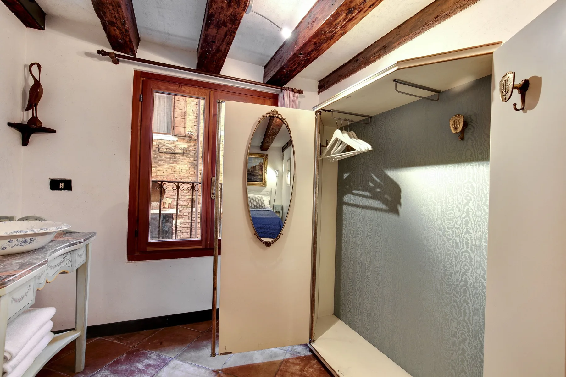 Un baño con lavabo, una zona de ducha abierta y vigas expuestas en el techo.