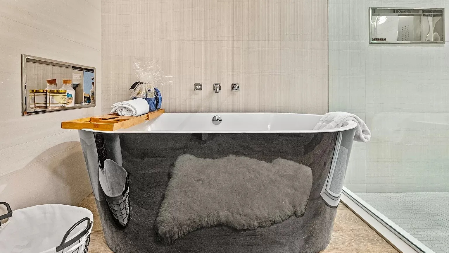 Un baño con una bañera exenta y una mampara de ducha de vidrio.