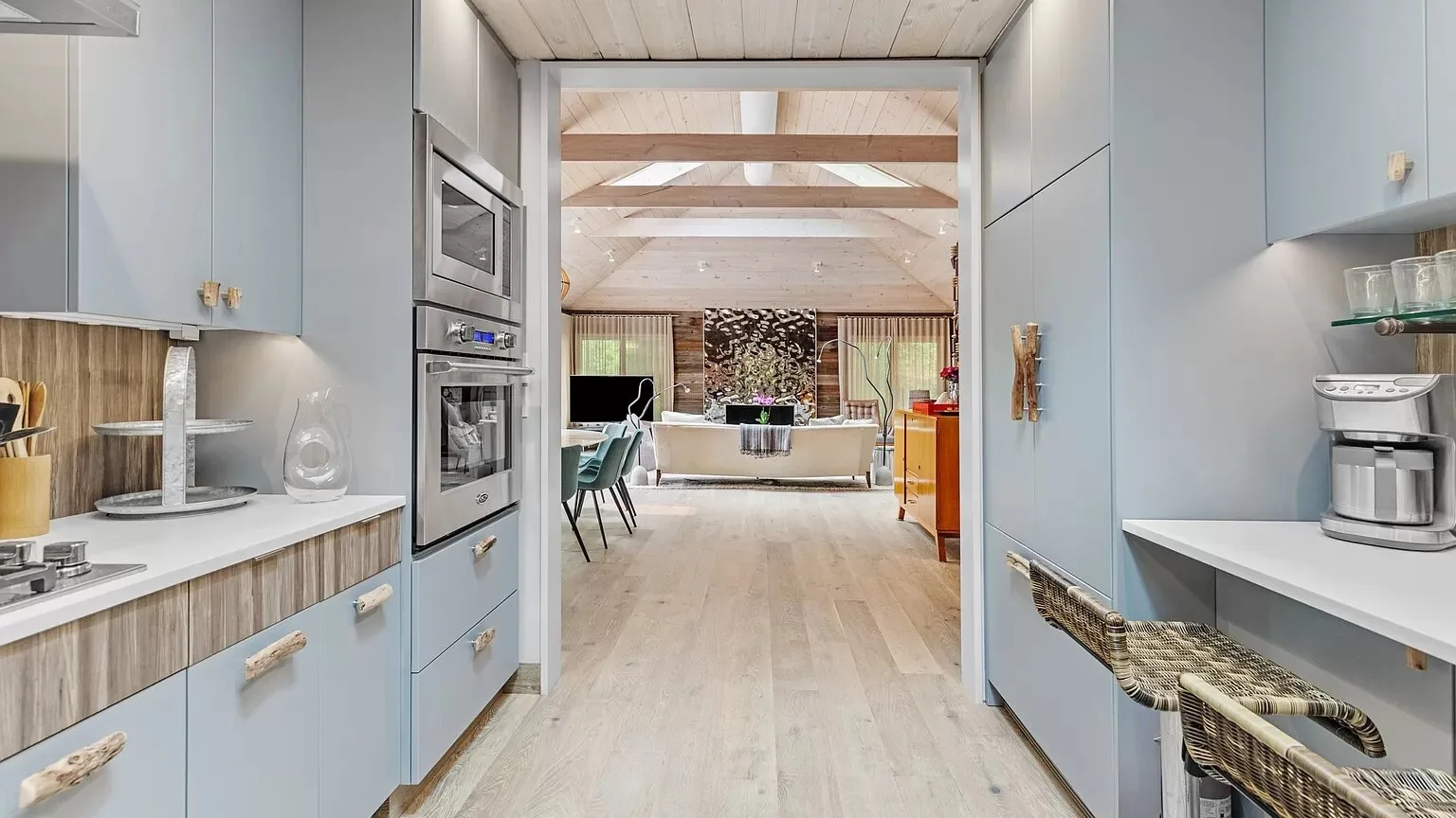 Una cocina moderna con gabinetes claros, hornos empotrados y una isla central.