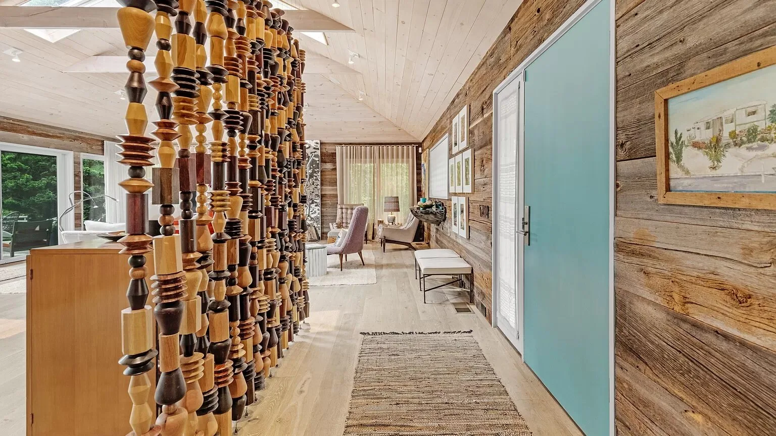 Una luminosa sala de estar con un divisor de madera escultural y una zona para sentarse al fondo.
