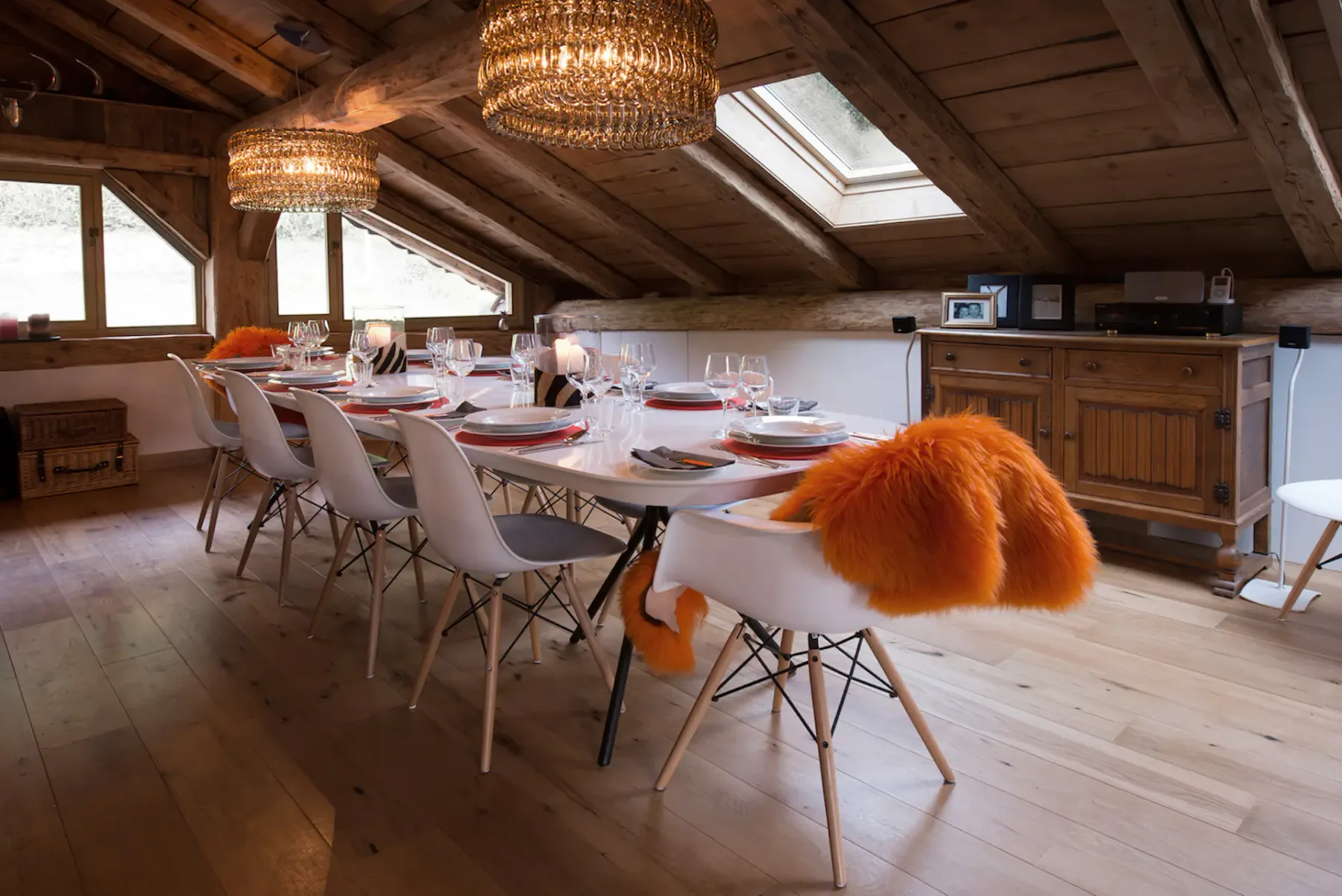 A dining room with a long set table beneath a sloped wooden ceiling.