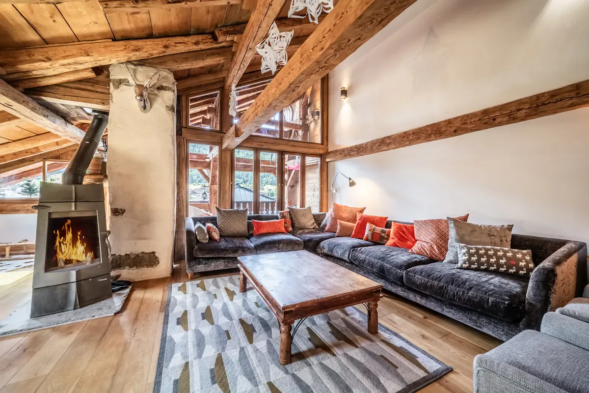 A living room with a sectional seating area and a wood-burning stove.