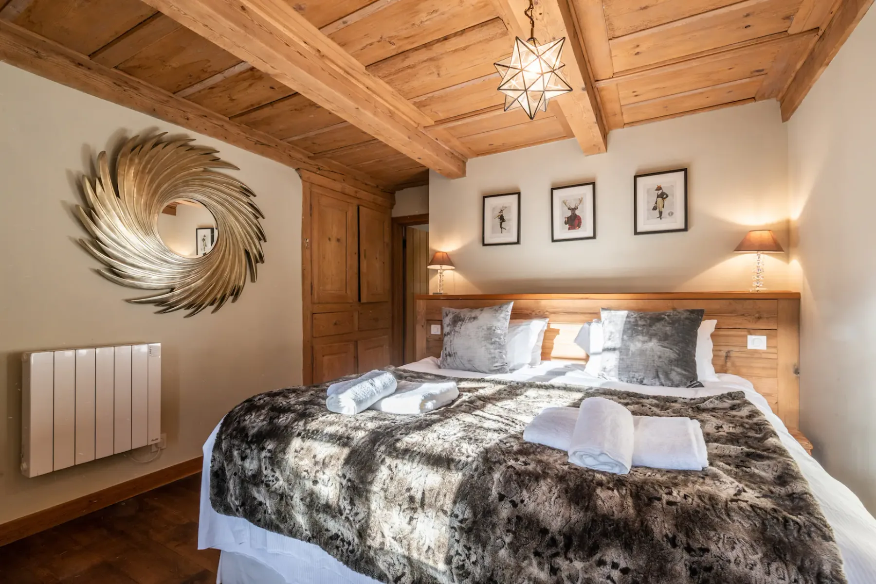 A bedroom with a double bed, patterned bedding, and a wood-paneled ceiling.