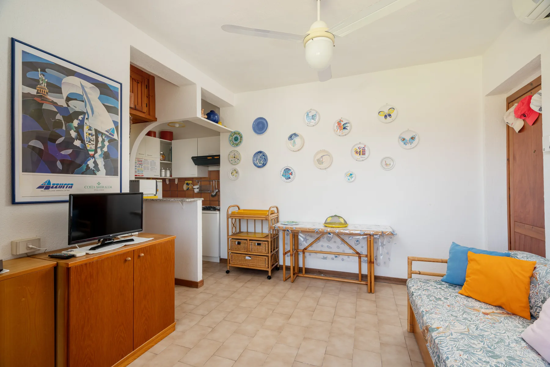 A bright living room with a television, dining table, and sofa.