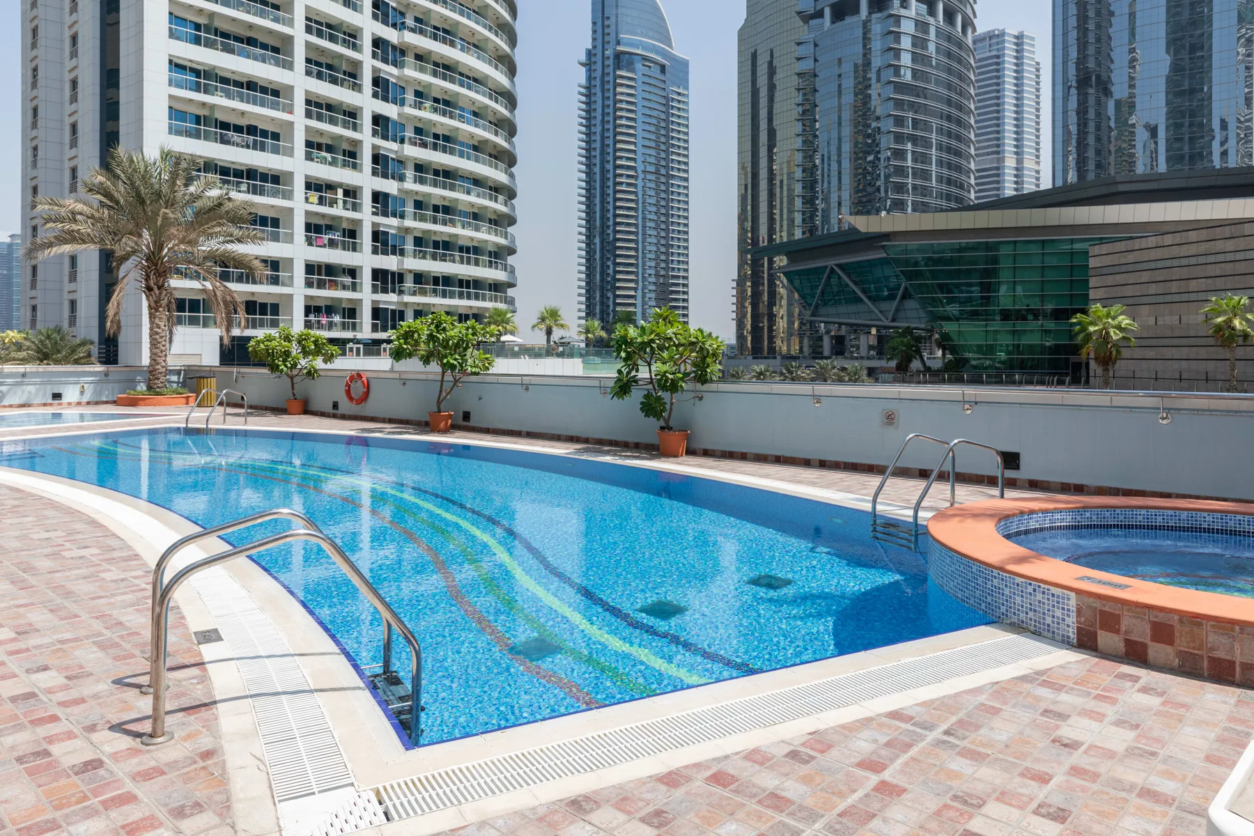Una piscina en la azotea está rodeada de altos edificios urbanos.