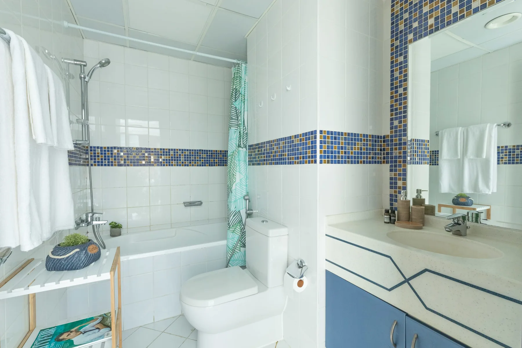 Un baño alicatado con bañera, inodoro y lavabo.